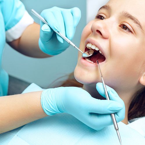 Girl getting checked by dentist