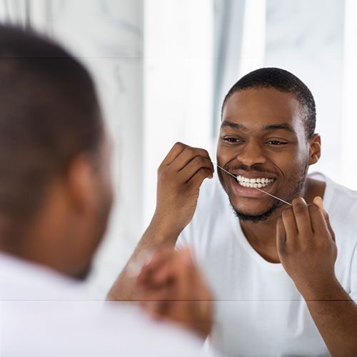 Man Flossing his teeth