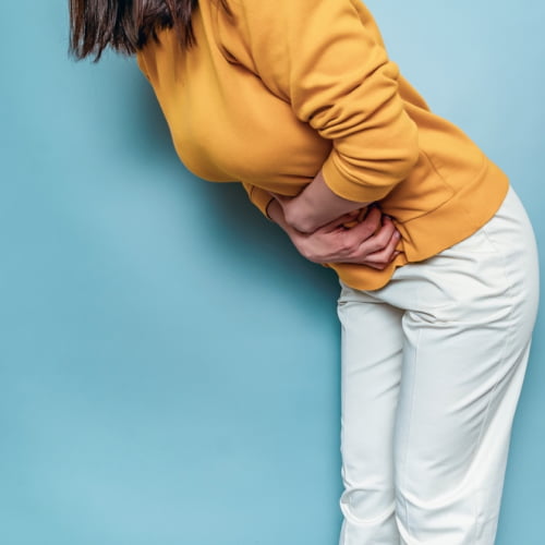 Women holding her lower abdomen